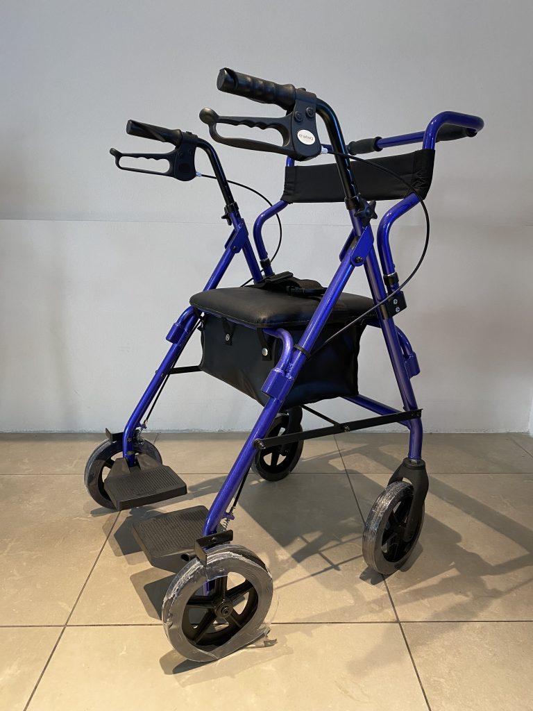 Rolletor 2 in 1 blu di Sanitaria Tiziana configurato con poggiapiedi per uso come sedia da transito e borsa portaoggetti.