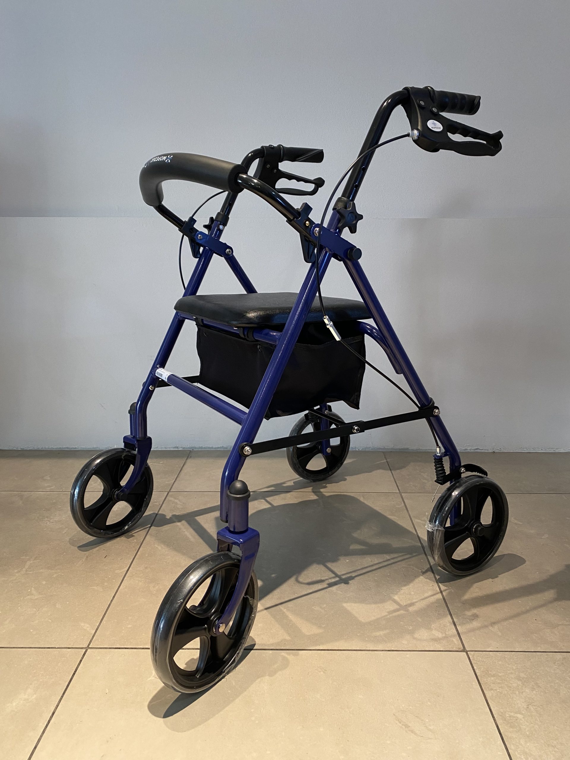 Rollator 2 in 1 blu per ginnastica passiva e mobilità con seduta, schienale imbottito e borsa portaoggetti.